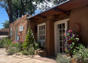 Clearlight Jewelry's shop front with adobe walls, flowers and blue skies.